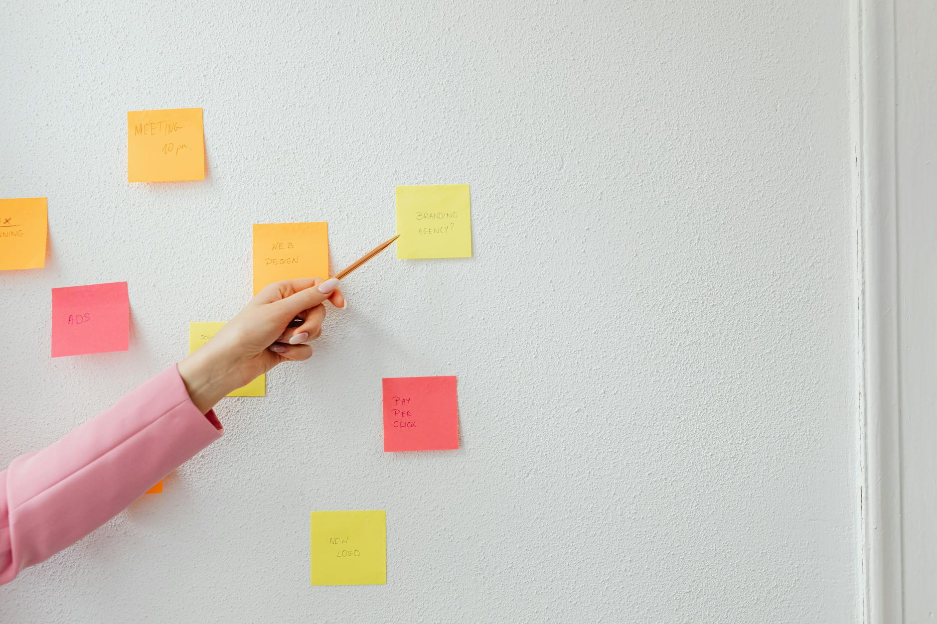 Hand demonstrating business planning using colorful sticky notes, perfect for creative and planning concepts.