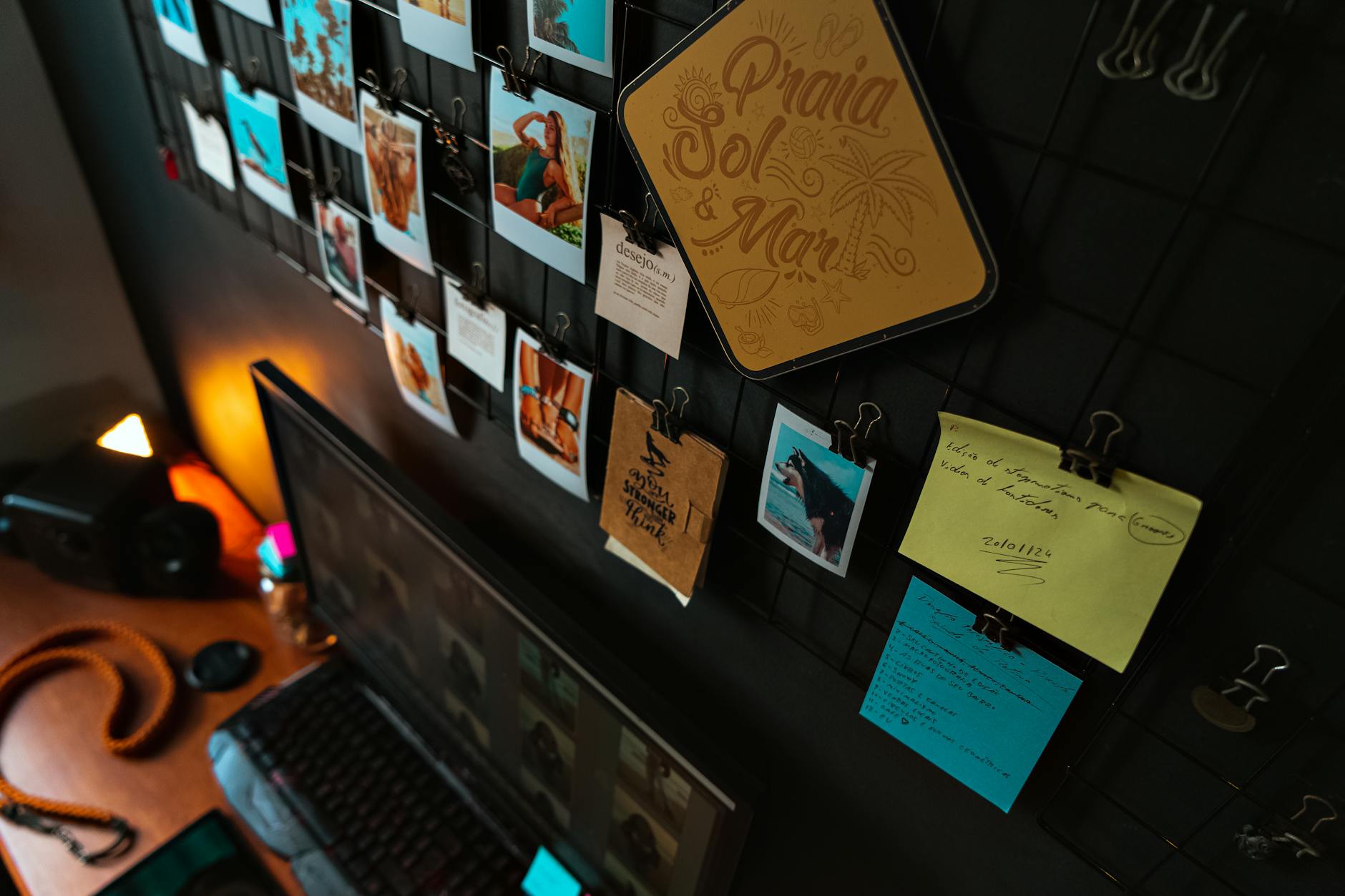 Modern workspace with photographs, notes, and a computer on a sleek desk.